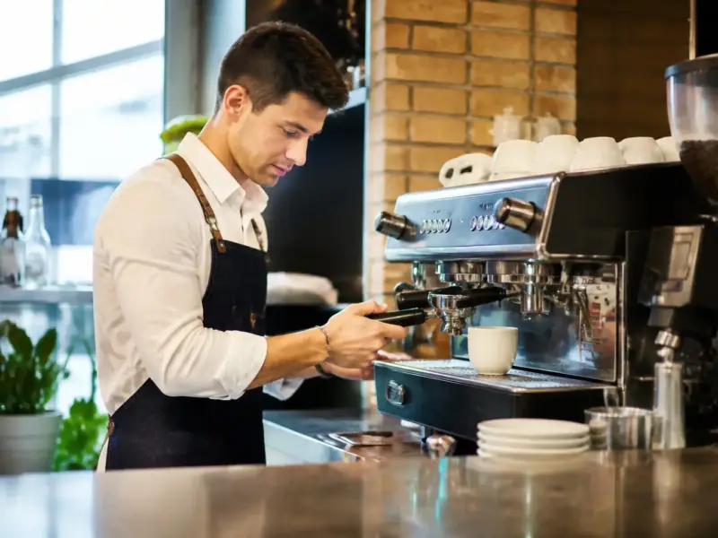 Barista durante la preparazione del servizio al banco